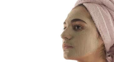 Beauty procedures skin care concept. Young woman applying facial mud clay mask to her face photo