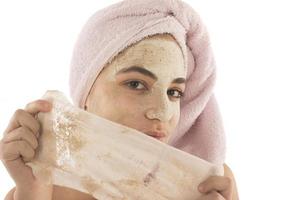 Beauty procedures skin care concept. Young woman applying facial mud clay mask to her face photo