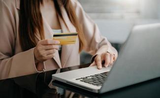 businesswoman hand using smart phone, tablet payments and holding credit card online shopping, omni channel, digital tablet docking keyboard computer at office photo