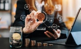 woman holding coins putting in glass with using smartphone and calculator to calculate  concept saving money for finance accounting with VR icon photo