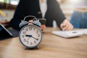 Alarm clock on the desk. Business working in modern office building or home at night using laptop. photo