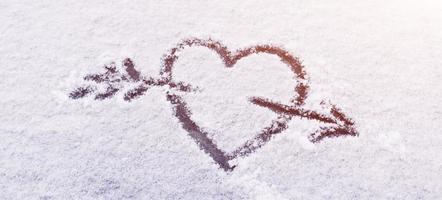 corazón en la nieve con una flecha foto