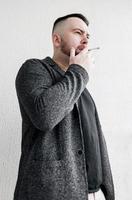 Young  bearded man smoking cigarette photo