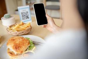 la gente usa el teléfono inteligente para escanear el código qr en el café. el restaurante construyó un sistema de pago digital sin efectivo. pago con código qr, billetera electrónica, tecnología de efectivo, pago en línea foto