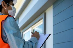 Inspectors or engineers are wearing an anti-virus mask and checking the building structure and the requirements of the wall paint. After the renovation is completed photo