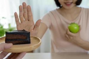 las mujeres de cuerpo delgado eligen durante los alimentos saludables y la comida chatarra, las mujeres eligen manzana verde para la dieta. buena comida saludable. bajar de peso, equilibrar, controlar, reducir grasa, bajar calorías, rutinas, hacer ejercicio. foto