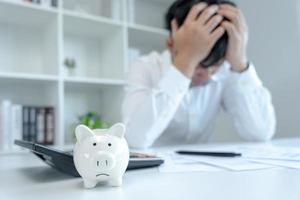 Stressed and headache asian man with large bills or invoices no money to pay to expenses and credit card debt. shortage, Financial problems, mortgage, loan, bankruptcy, bankrupt, poor, empty wallet photo