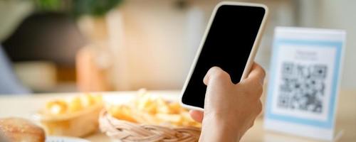 people use smartphone to scan QR code in cafe. The restaurant built a digital payment system without cash. Qr code pay, E wallet, cash technology, pay online photo