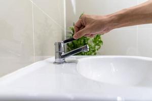 Save water. Volunteer keeps turning off the running water in the bathroom to protect environment. Greening planet, reduce global warming, Save world, life, future, risk energy, crisis , water day. photo