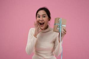 Celebration holiday, Presents. Young asian woman happy and smile hold gift boxes in party for celebrating birthday on pink background, Enjoy female receive new year gift, christmas day, valentine day. photo