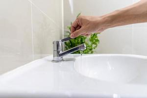 Save water. Volunteer keeps turning off the running water in the bathroom to protect environment. Greening planet, reduce global warming, Save world, life, future, risk energy, crisis , water day. photo