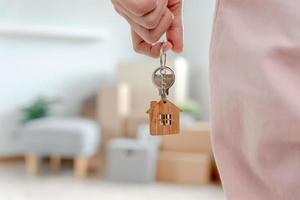 Moving house, relocation. Woman hold key house keychain in new apartment. move in new home. Buy or rent real estate. flat tenancy, leasehold property, new landlord, dwelling, loan, mortgage. photo