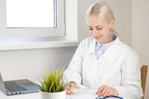 pancarta de atención médica con un joven médico feliz llenando papeleo y escribiendo recetas foto