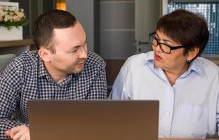 Son explaining mother how to use apps on computer. photo