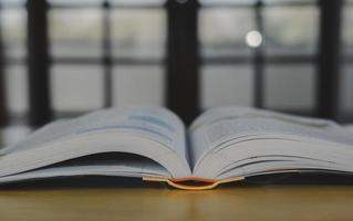 pila o capa de libros antiguos antiguos sobre una mesa de madera. concepto de aprendizaje, educación y estudio. uno de ellos abierto con espacio de copia. foto