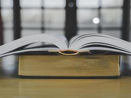 pila o capa de libros antiguos antiguos sobre una mesa de madera. concepto de aprendizaje, educación y estudio. uno de ellos abierto con espacio de copia. foto