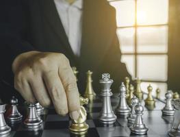 Concentrated businessman developing chess gambit, strategy ,playing board game to winner clever concentration and thinking while playing chess. Learning, tactics and analysis concept. photo