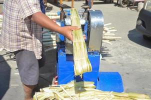 pequeñas máquinas para triturar y extraer el jugo de la caña de azúcar. mercado de tailandia foto