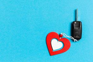 Top view of car key and wooden heart on colorful background. Saint Valentine's Day concept with copy space photo