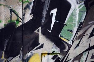 un fragmento de grafiti detallado de un dibujo realizado con pinturas en aerosol sobre una pared de baldosas de hormigón. imagen de fondo del arte callejero en tonos marrones y crema foto