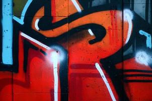 un fragmento de grafiti detallado de un dibujo realizado con pinturas en aerosol sobre una pared de baldosas de hormigón. imagen de fondo del arte callejero en cálidos tonos rojos foto
