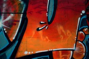 A fragment of detailed graffiti of a drawing made with aerosol paints on a wall of concrete tiles. Background image of street art in warm red color tones photo