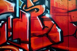 A fragment of detailed graffiti of a drawing made with aerosol paints on a wall of concrete tiles. Background image of street art in warm red color tones photo