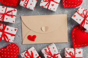 Envelope Mail with Red Heart and gift box over grey cement Background. Valentine Day Card, Love or Wedding Greeting Concept photo