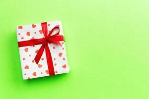 Background with gift box and hearts on green Background. Top view with copy space for text photo