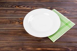 Empty plate over wooden table background. View from above with copy space photo