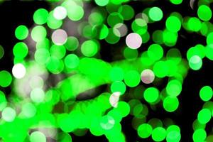Unfocused abstract colourful bokeh black background. defocused and blurred many round green light photo
