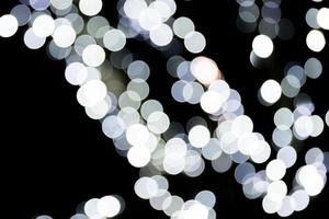 Abstract bokeh of white city lights on black background. defocused and blurred many round light photo