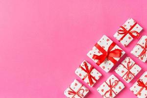 Holiday composition of gift boxes with red hearts on colorful background with empty space for your design. Top view of Valentine's Day concept photo