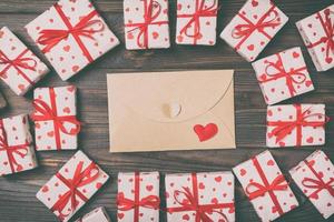 Valentines day mock up. envelope in gift boxes frame on wooden vintage toned background. Valentines day card concept photo