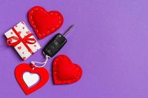 Top view of car key, gift boxes and toy hearts on colorful background. Saint Valentine's Day concept with copy space photo