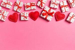 Top view of gift boxes and red textile hearts on colorful background. St Valentine's day concept with copy space photo