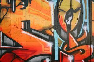 A fragment of detailed graffiti of a drawing made with aerosol paints on a wall of concrete tiles. Background image of street art in warm red color tones photo