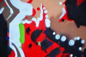 Background image with graffiti elements. Texture of the wall, painted in different colors of in the graffiti style. Concept of street culture, youth entertainment and illegal hooliganism photo