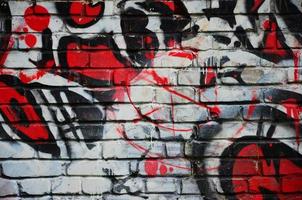 Some elements of a large and composite graffiti pattern on the wall, made with different colors of aerosol paints photo
