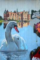 A fragment of detailed graffiti of a drawing made with aerosol paints on a wall of concrete tiles. Background image of street art with a huge white swan photo