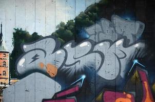 un fragmento de grafiti detallado de un dibujo realizado con pinturas en aerosol sobre una pared de baldosas de hormigón. imagen de fondo del arte callejero en tonos grises foto