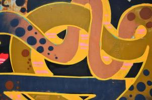 Some elements of a large and composite graffiti pattern on the wall, made with different colors of aerosol paints photo