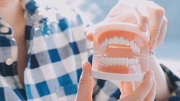 conceito de estomatologia, retrato parcial de menina com fortes dentes brancos, olhando para a câmera e sorrindo, dedos perto do rosto. closeup de jovem no dentista, estúdio, dentro de casa video