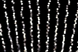 Abstract glitter sparkle bokeh defocused on black background. many round light on background photo