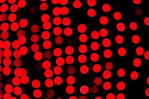 Unfocused abstract red bokeh on black background. defocused and blurred many round light photo