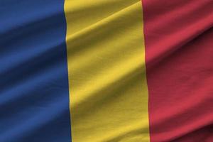 Romania flag with big folds waving close up under the studio light indoors. The official symbols and colors in banner photo