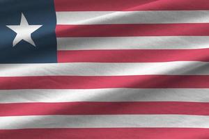 Liberia flag with big folds waving close up under the studio light indoors. The official symbols and colors in banner photo