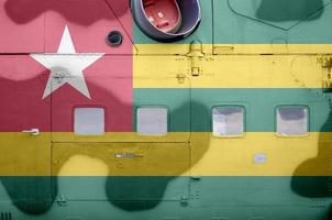 Togo flag depicted on side part of military armored helicopter closeup. Army forces aircraft conceptual background photo