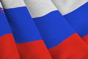 Slovenia flag with big folds waving close up under the studio light indoors. The official symbols and colors in banner photo
