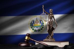 El Salvador flag with statue of lady justice, constitution and judge hammer on black drapery. Concept of judgement and guilt photo